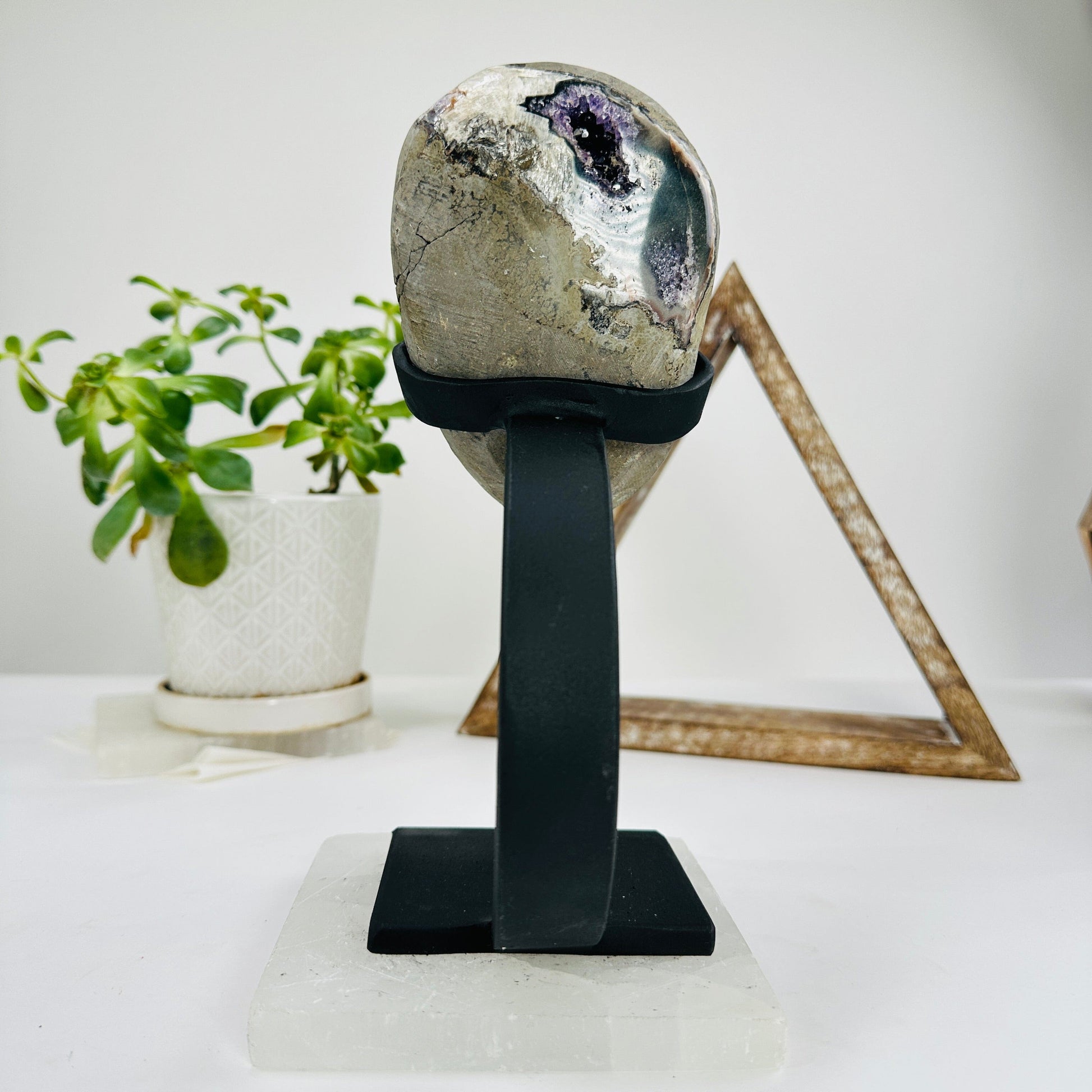 amethyst on metal stand with decorations in the background