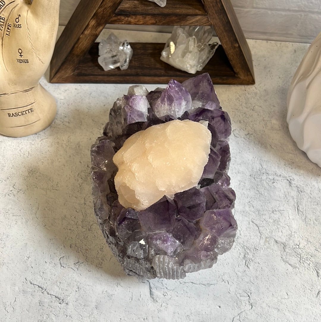 Large high quality purple amethyst cluster with a large cream color calcite formation around the center of it.
