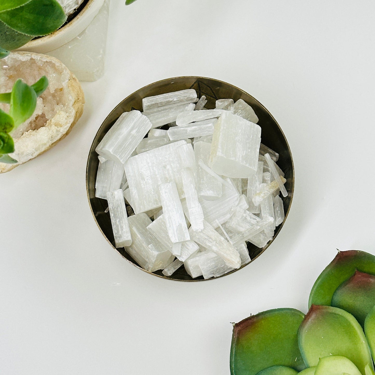 bowl filled with selenite chips with decorations in the background