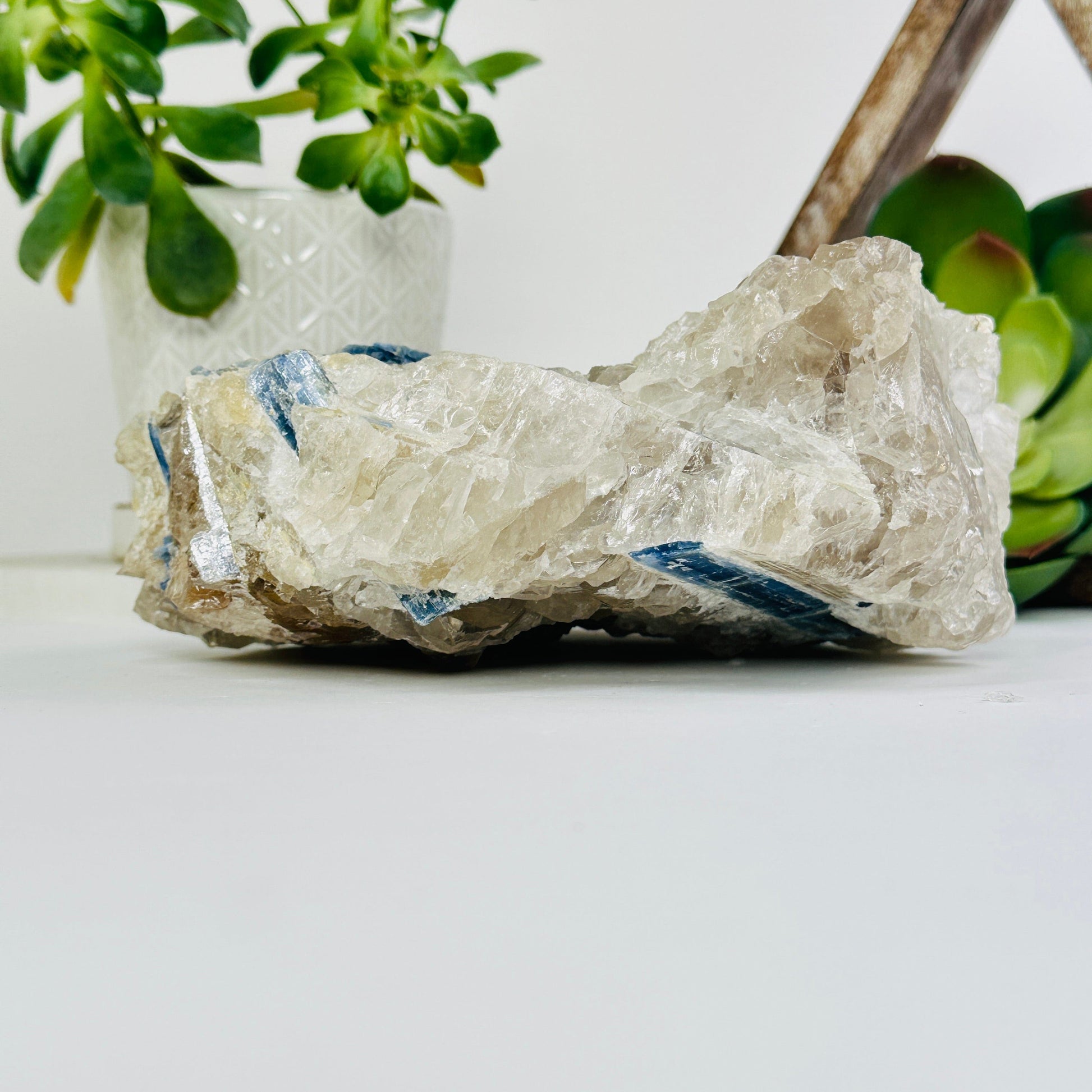 blue kyanite on matrix with decorations in the background