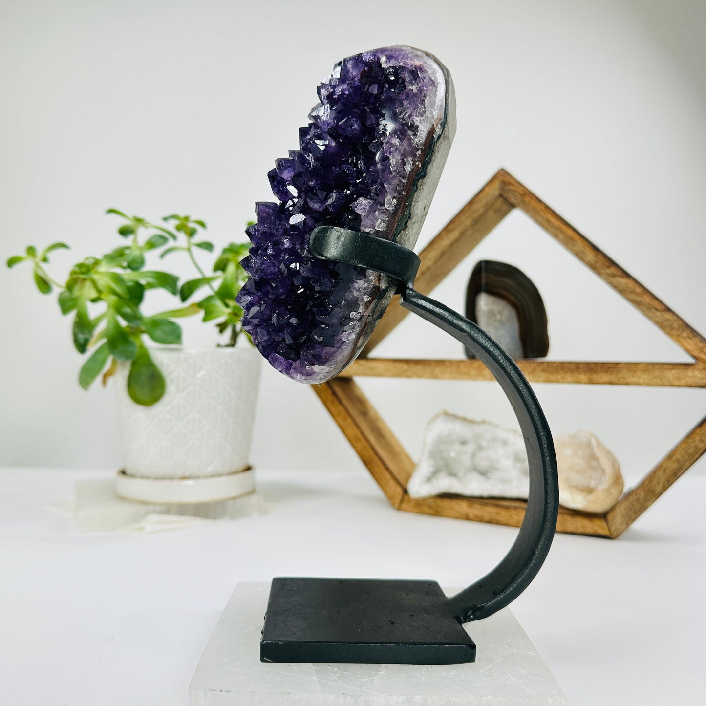amethyst on metal stand with decorations in the background