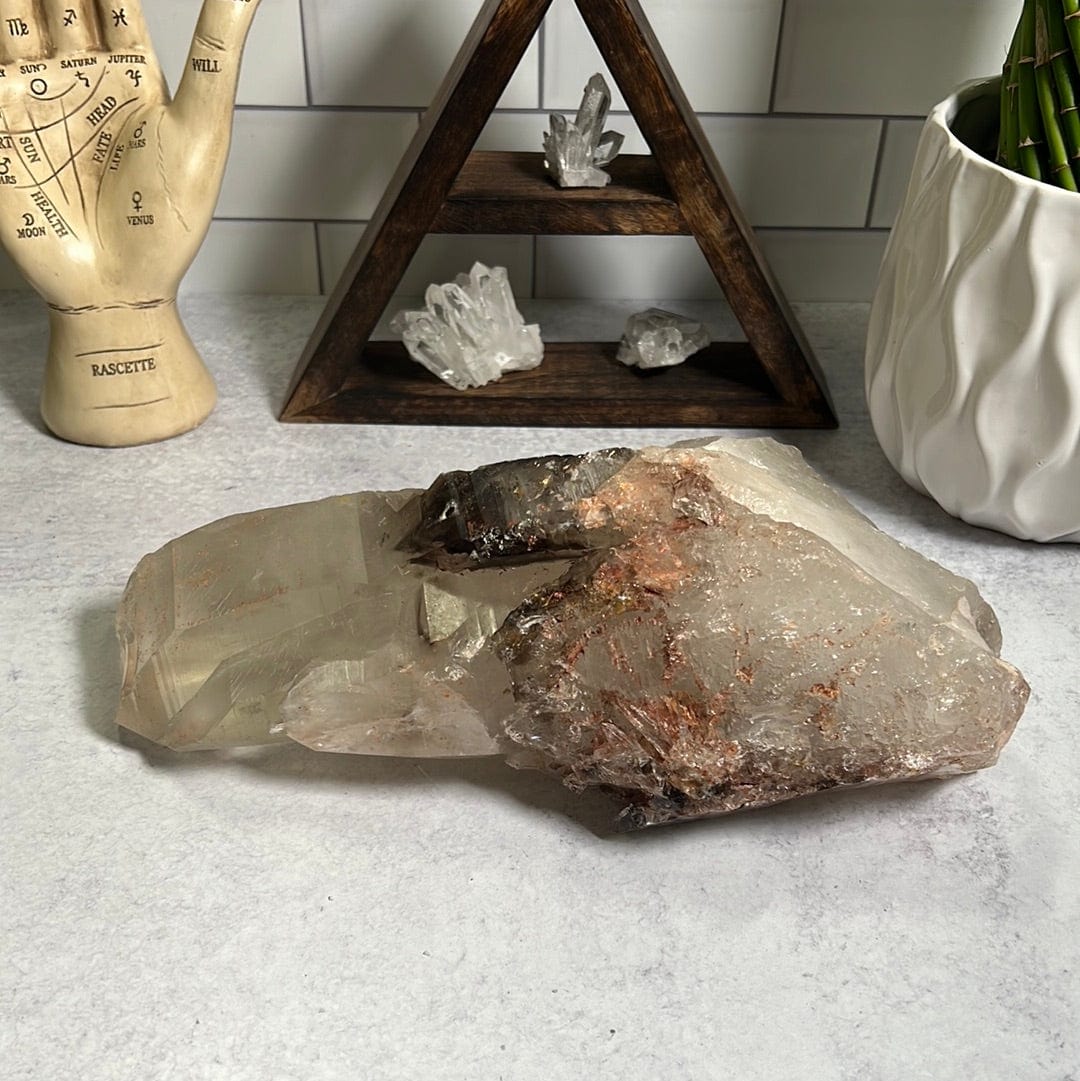 large smokey Quartz cluster on a cement background.