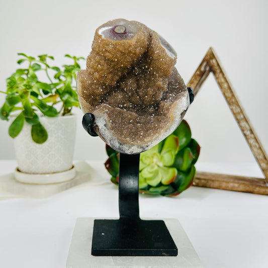 amethyst on metal stand with decorations in the background