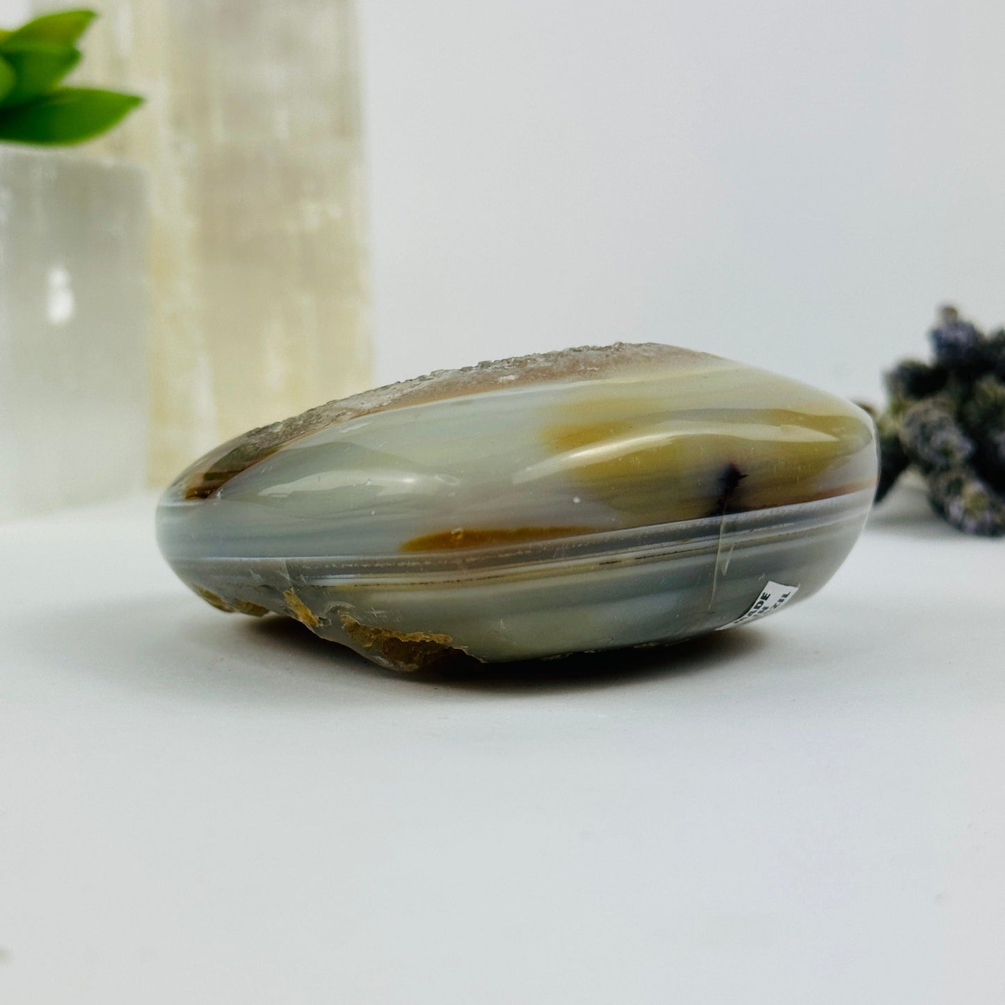 Side view of agate heart with decorations in the background