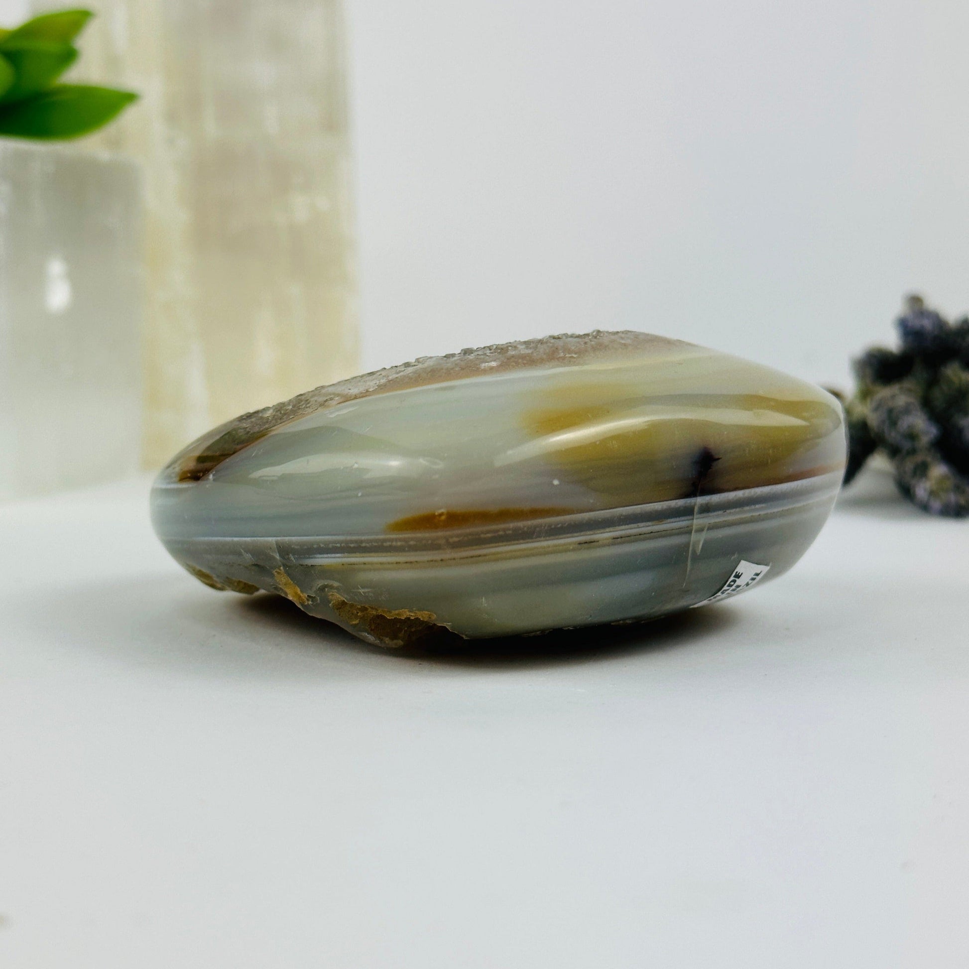 Side view of agate heart with decorations in the background