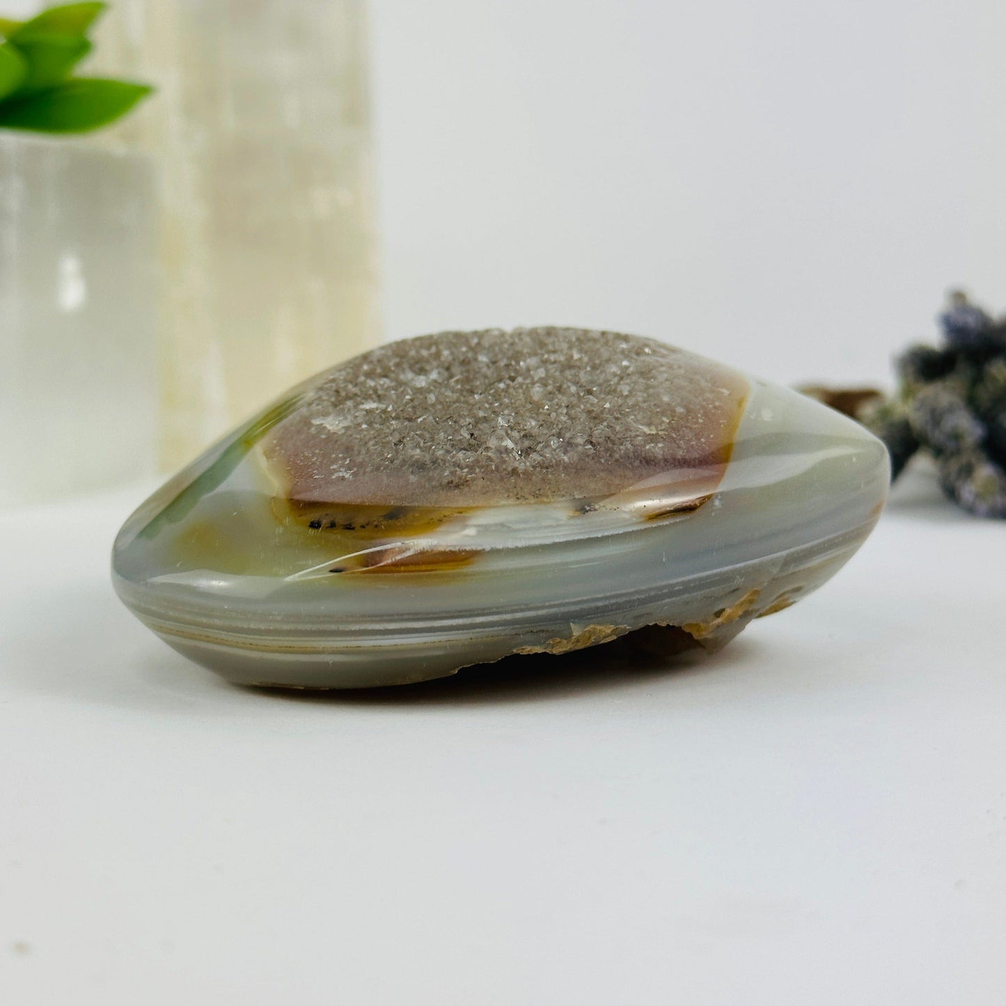 Side view of agate heart with decorations in the background