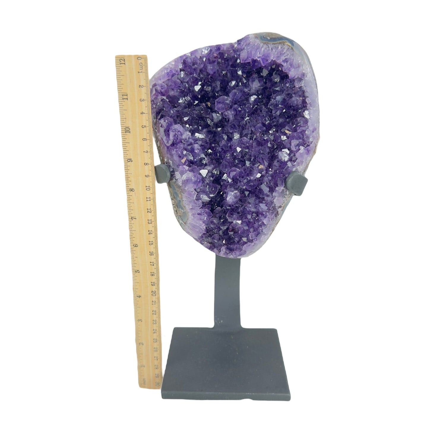 amethyst on stand next to a ruler for size reference