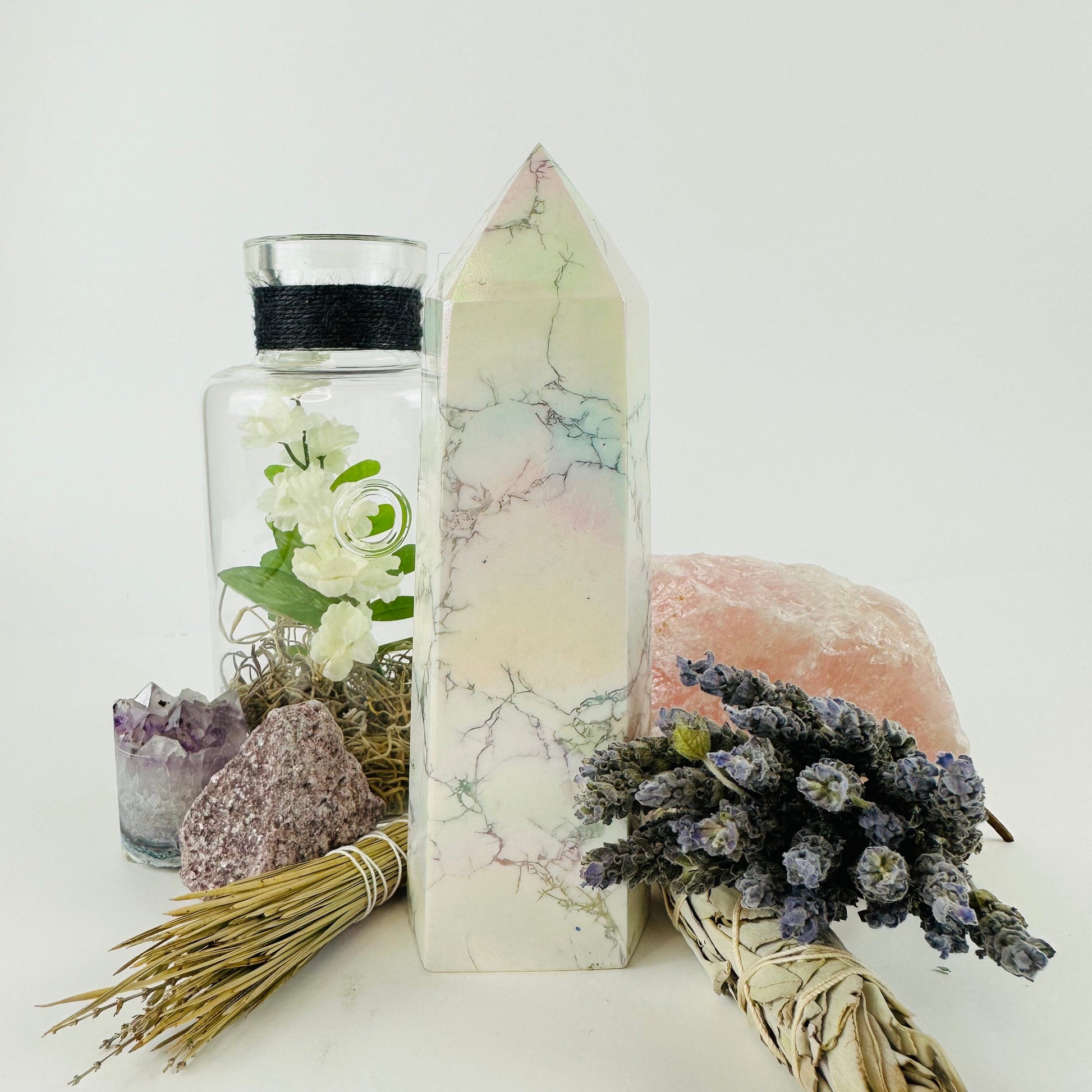 White howlite aura tower surrounded with decorations on white background