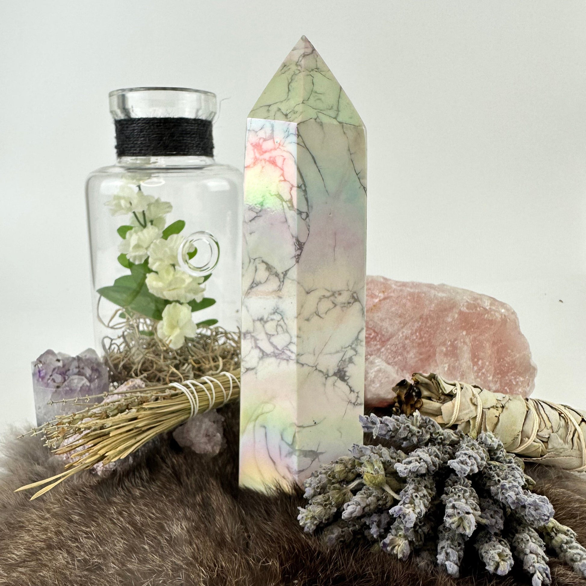 side view of white howlite aura tower with decorations in the background