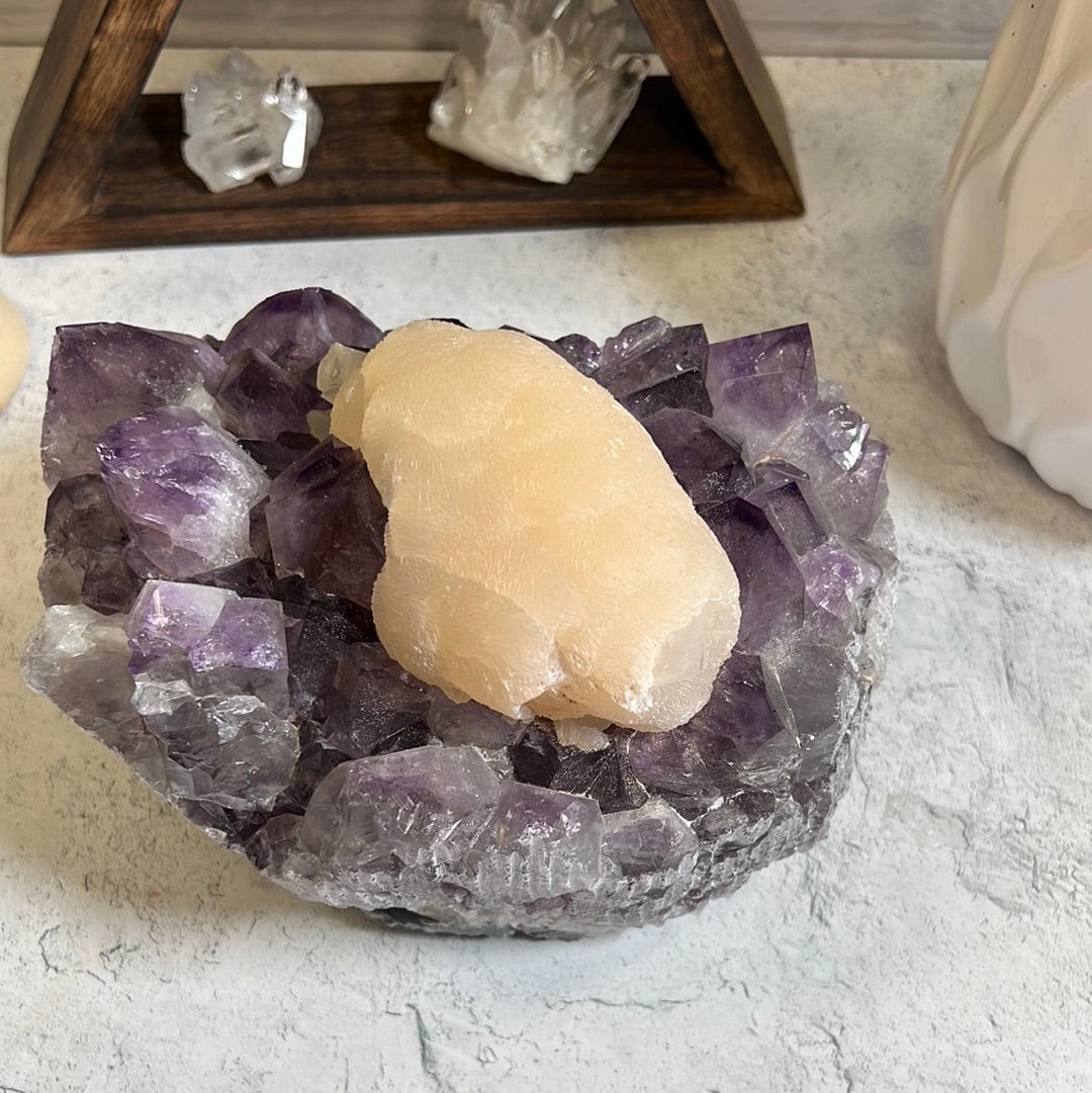 Large high quality purple amethyst cluster with a large cream color calcite formation around the center of it.