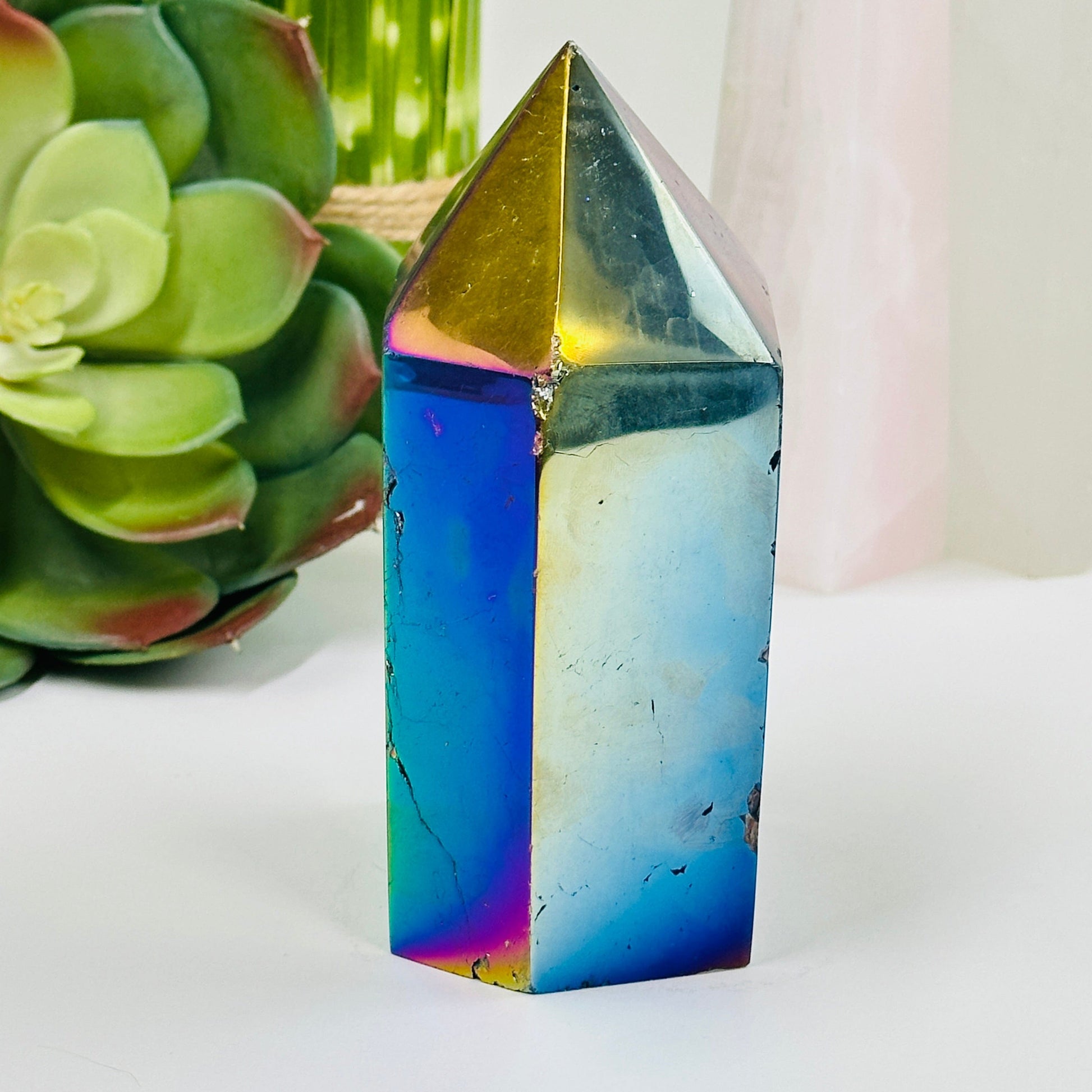 side view of rainbow titanium agate point with decorations in the background