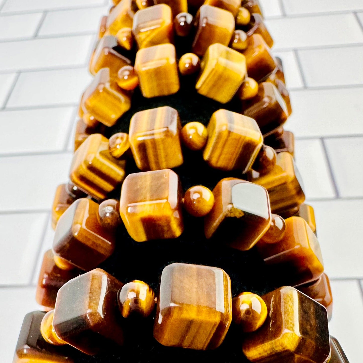 Up close aerial view of 8 tigers eye bracelets on black bracelet display.