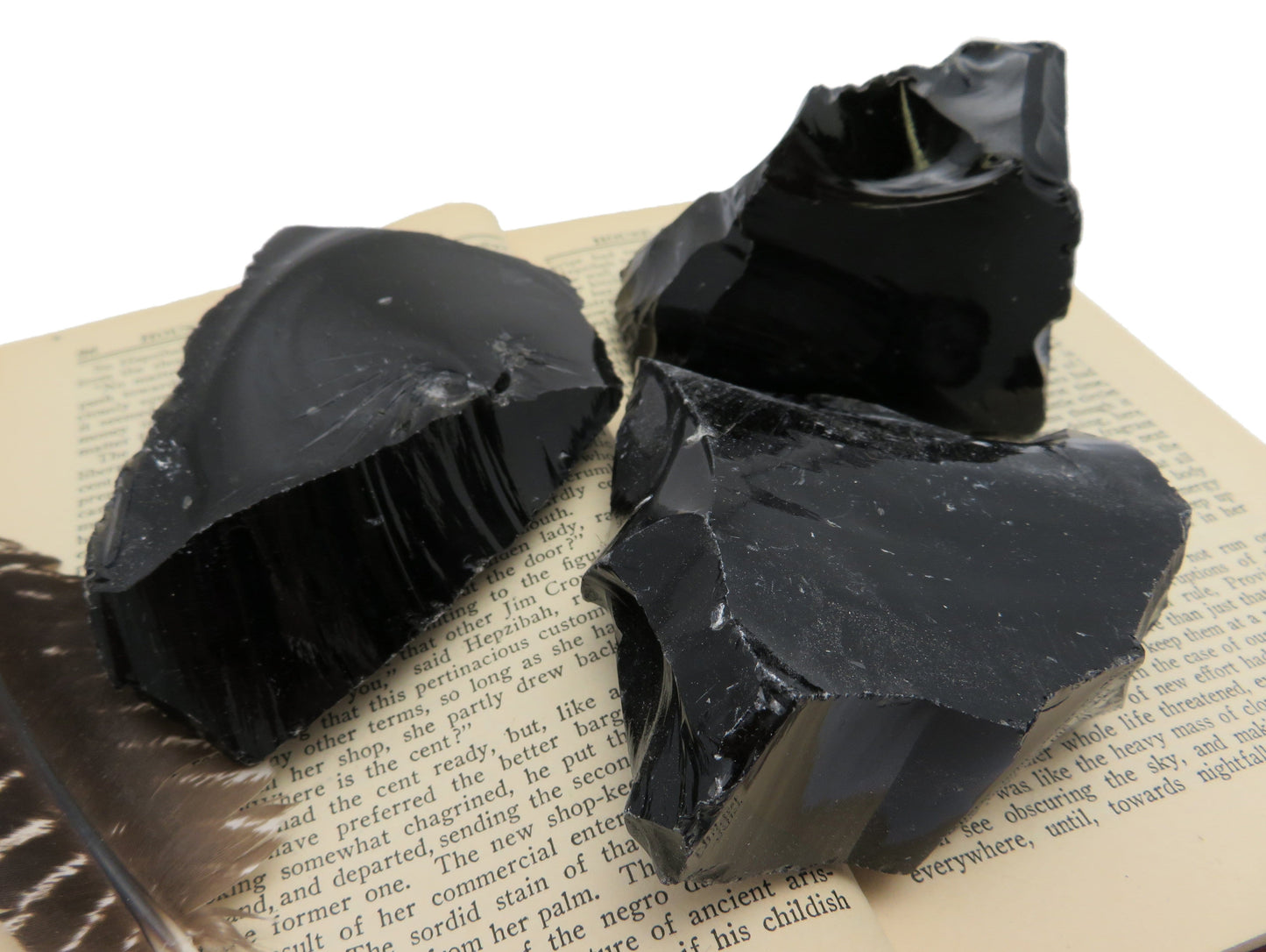 Products Obsidian Chunk -  a close up of the three on a book