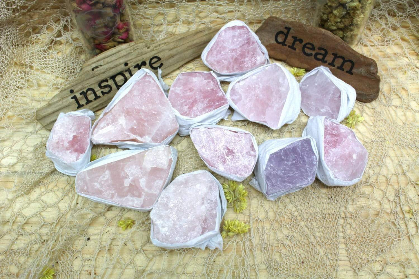 Rough Rose Quartz pieces on lacey background with "Inspire" and "dream" signs