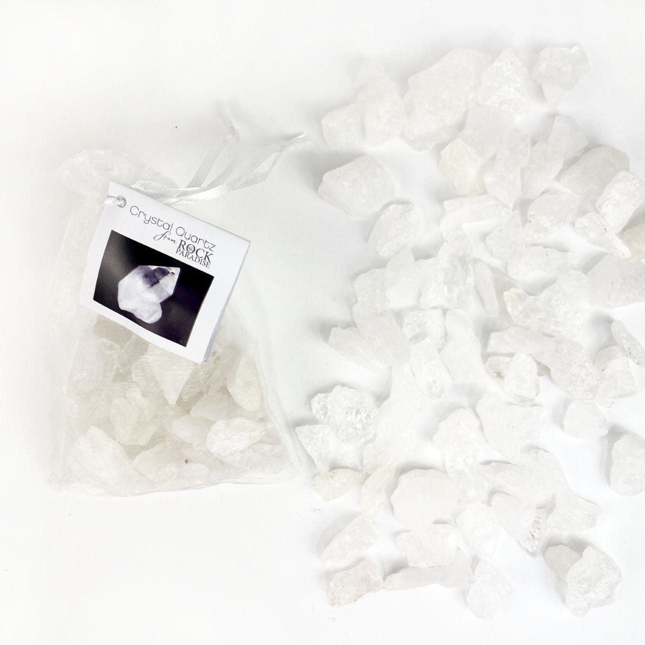 Crystal Quartz Stones - Tied & Tagged in an Organza Bag next to stones on a table