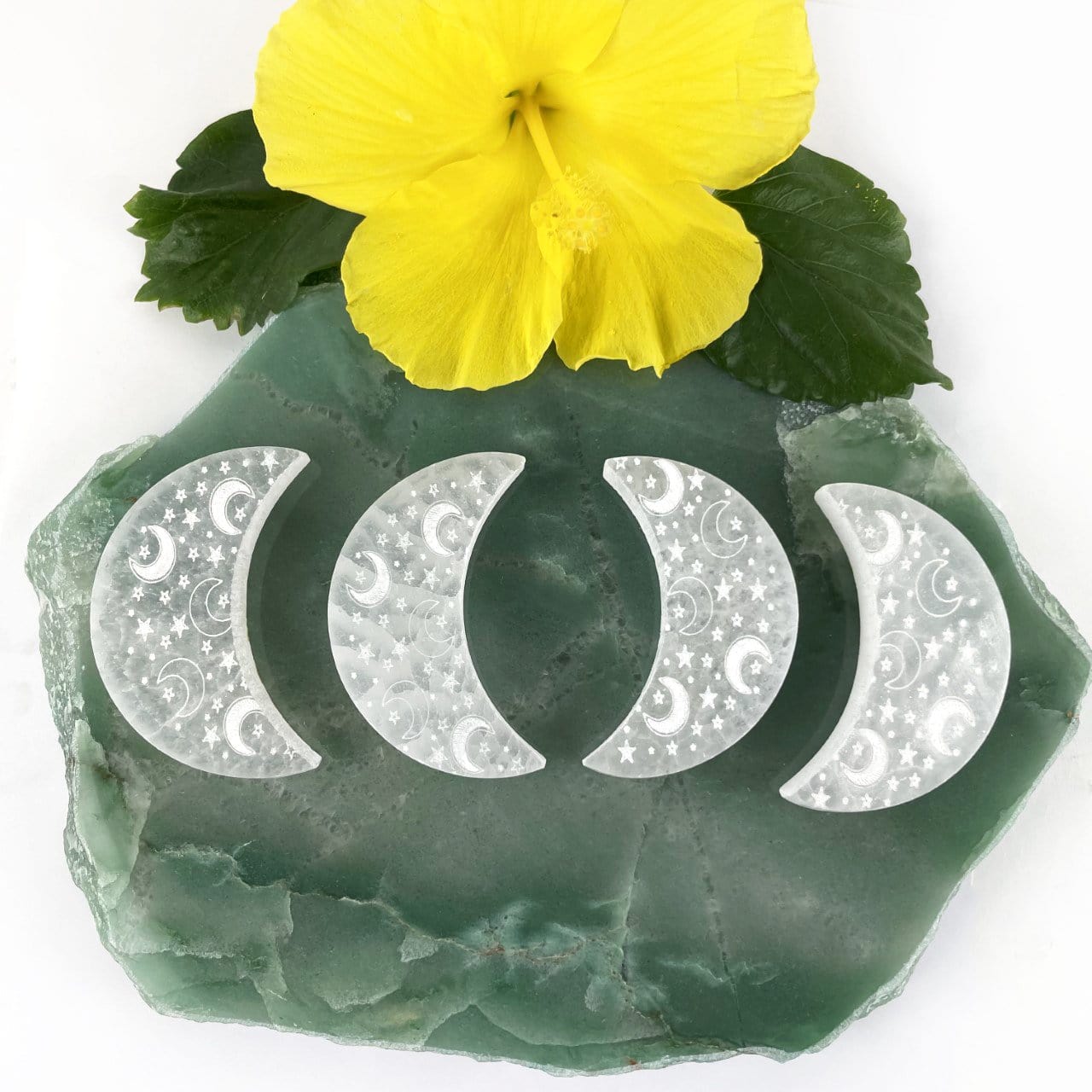 selenite engraved crescent moon charging plates on display for engraving detail and variation