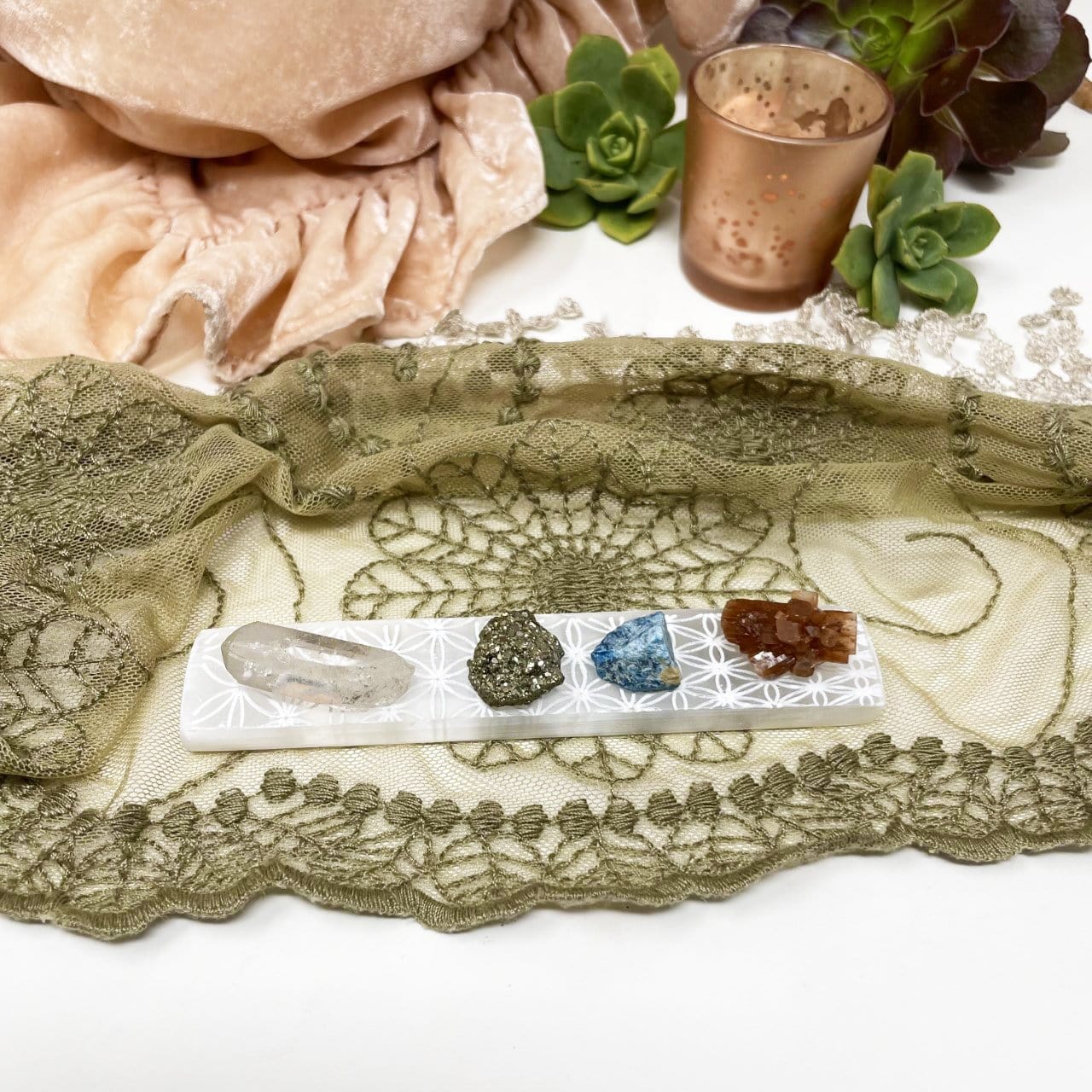 flower of life engraved selenite charging stick with stones on display