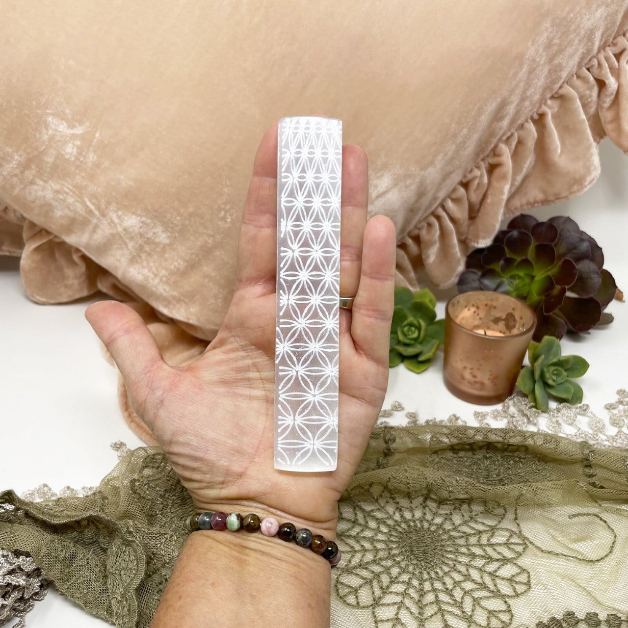 flower of life engraved selenite charging stick in hand for size reference