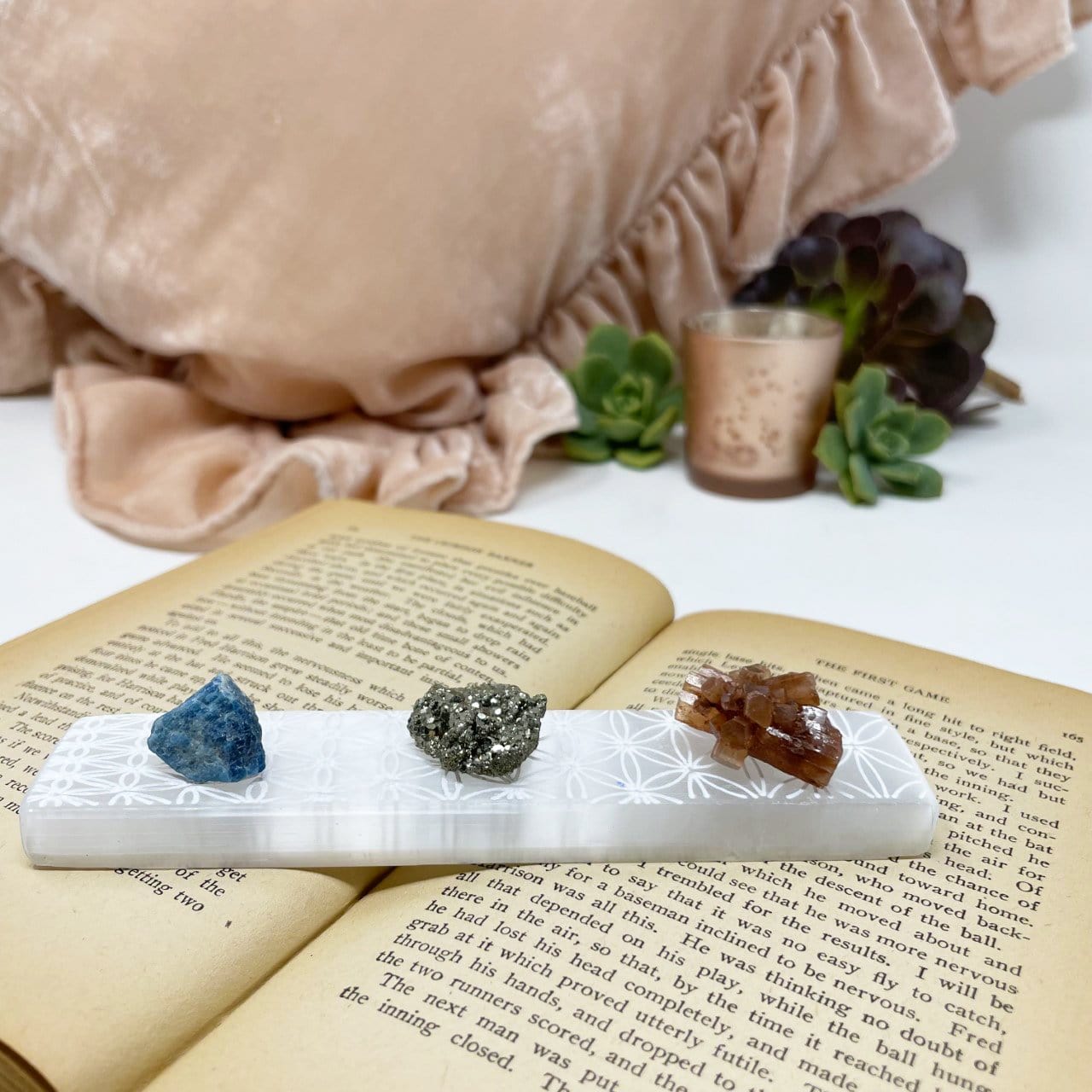 flower of life engraved selenite charging stick with stones on display