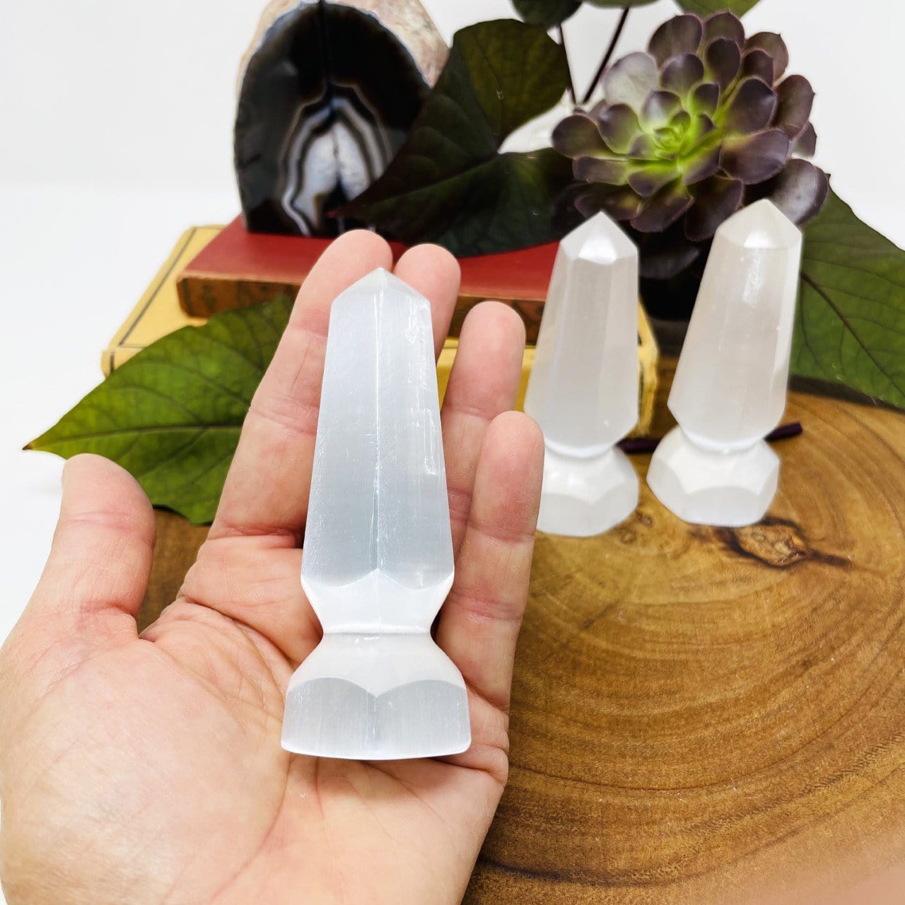 selenite spear tip in hand for size reference with others in background