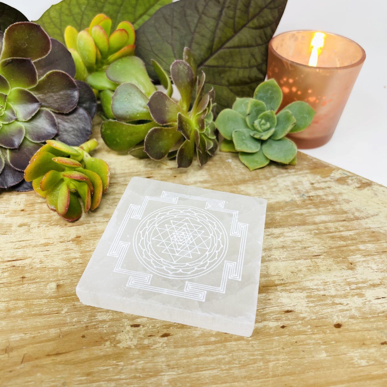 angled view of selenite shri yantra mandala engraved square charging plate for approximate thickness